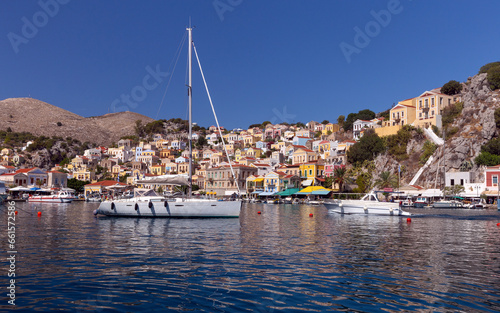 White yacht against the backdrop of high mountains in the bay of Symi island.