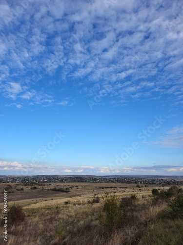 A landscape with a blue sky and clouds