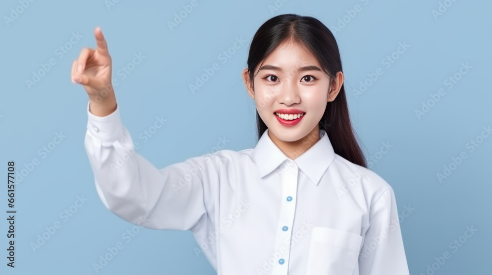 smiling of teen student girl of Asian ethnicity in university uniform pointing finger away. smiling of teen student girl of Asian ethnicity in university uniform pointing finger away.
