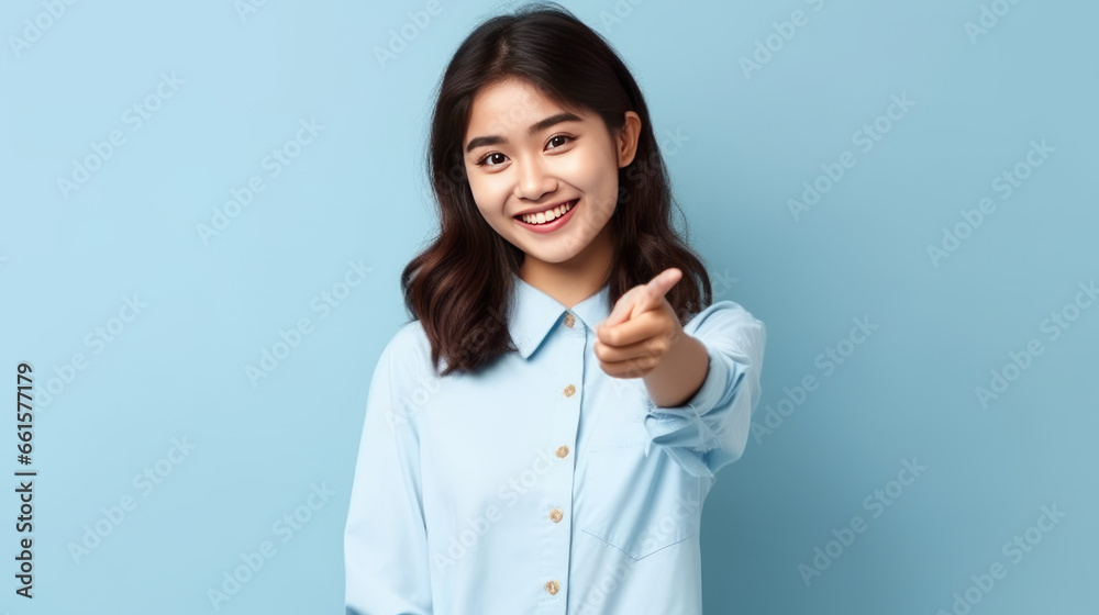 smiling of teen student girl of Asian ethnicity in university uniform pointing finger away. smiling of teen student girl of Asian ethnicity in university uniform pointing finger away.