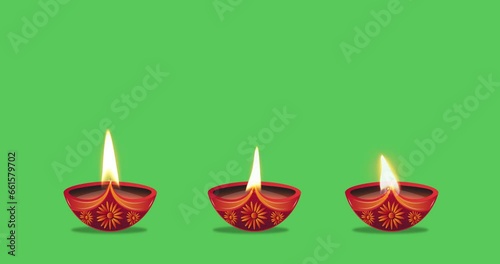 Oil lamps burning in three different ways on a green background. Diwali celebration, festival of lights, Karthika Deepa Festival.