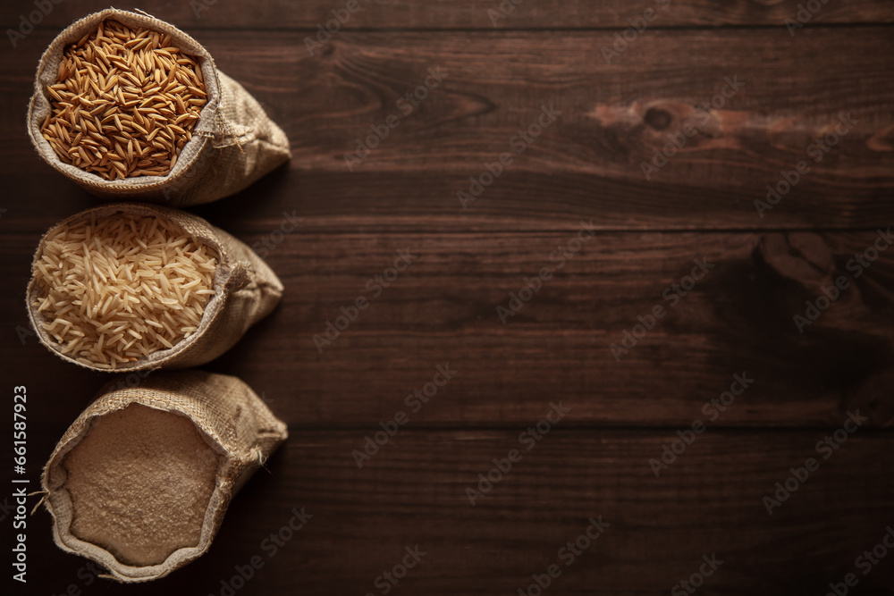 A trio of different stages of organic Rice (Oryza sativa) in a jute bag. Rice Bran, Rice, and Rice Flour on a dark wooden background. Top view.