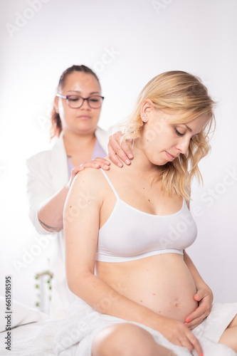 Sensual future mother touching belly during massage