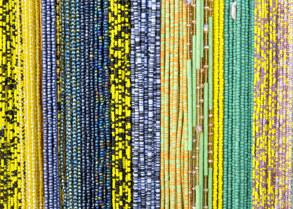 close up on strings of beads in black, yellow, purple and gold. Popular hair decorations in some cultures.