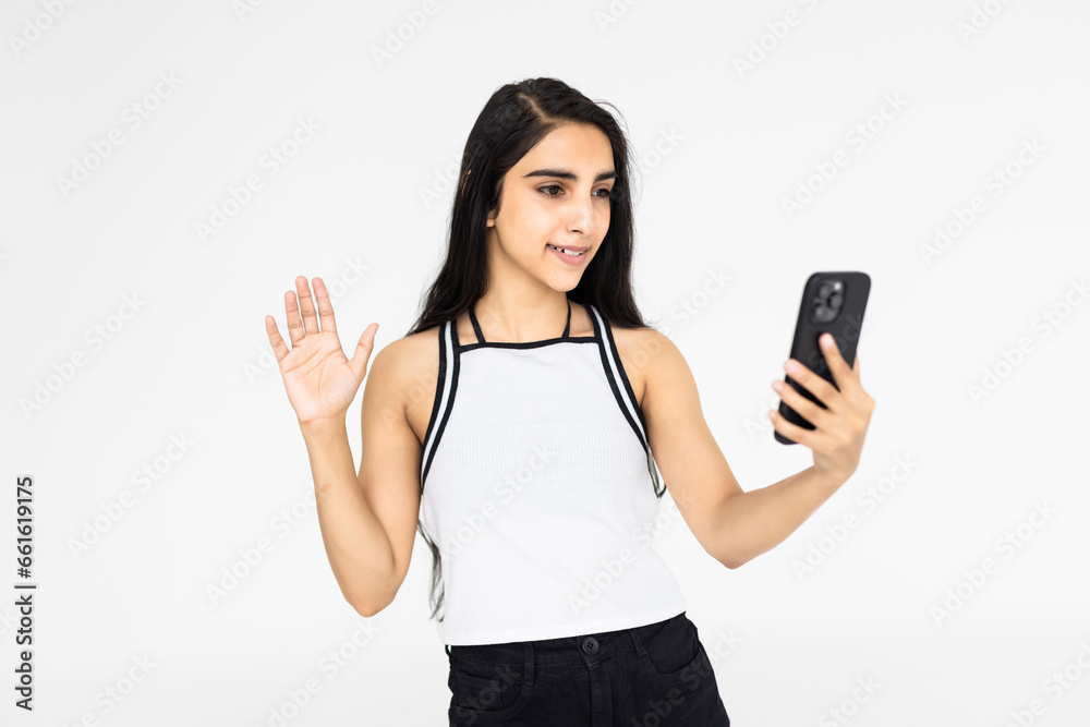 Indian happy woman with a in saree taking selfie and doing a video call in white background. Indian happy woman with a in saree taking selfie and doing a video call in white background.