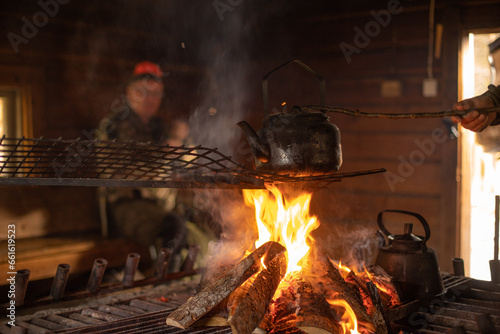 Hunters making coffe with the fire of a bonfire in a wooden windshelter in nature.jpg