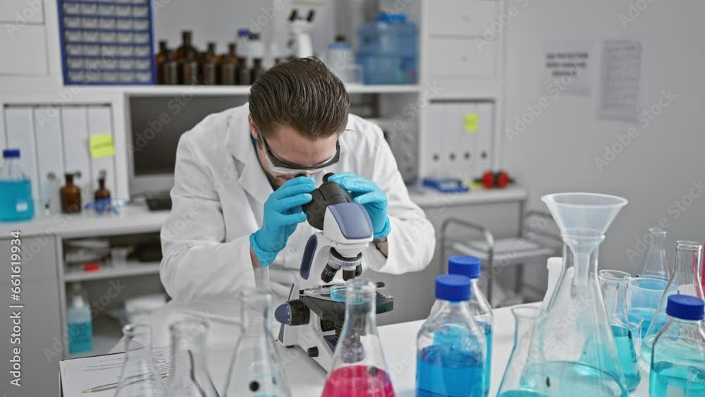 Young hispanic man scientist smiling confident using microscope celebrating at laboratory Young hispanic man scientist smiling confident using microscope celebrating at laboratory