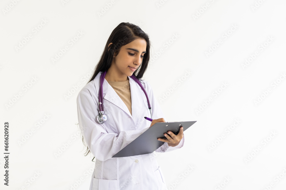 Smiling indian female doctor holding a clipboard on white background Smiling indian female doctor holding a clipboard on white background