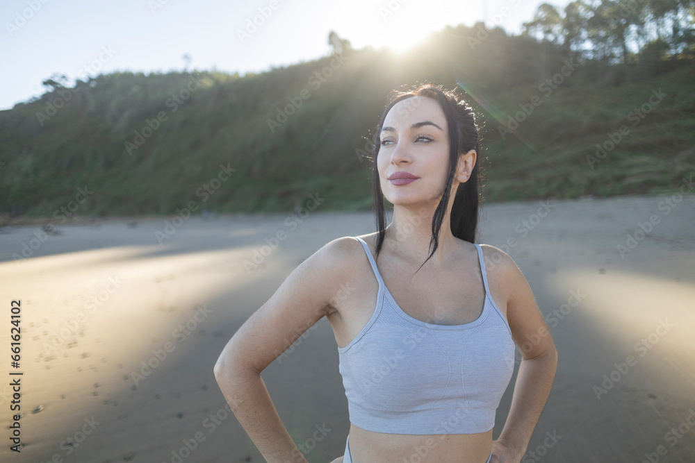 young caucasian woman does sports on the beach at sunrise, resting young caucasian woman does sports on the beach at sunrise, resting