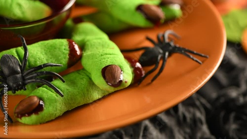 A delicious Halloween treat, Witch Fingers Green Sugar Cookies with raspberry jam and almonds   are the perfect choice. Trick-or-treat. Slow motion, in a circle. Close-up photo