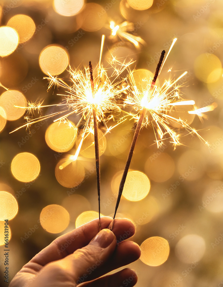 new year concept with hand holding sparkler bokeh background
