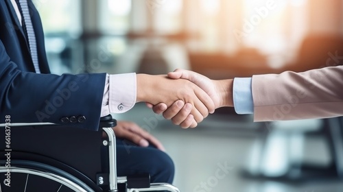 Business meeting in a co-working space. A man in a wheelchair shaking hands. Integration of people with disabilities.