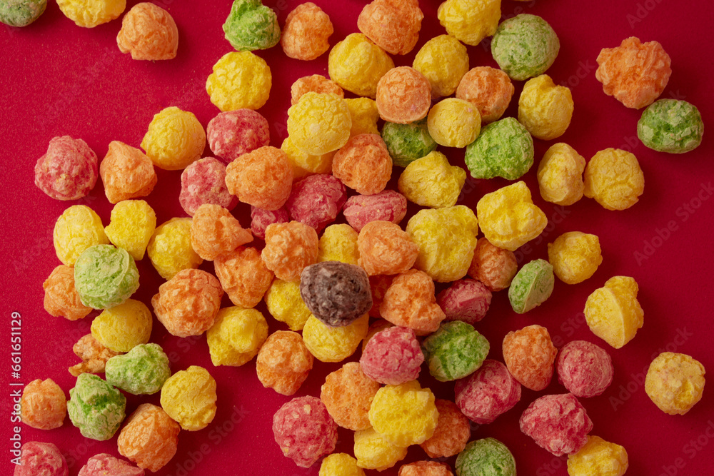 colorful cereal candies on red background 