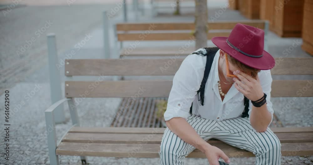 Man with head in hand sitting on bench