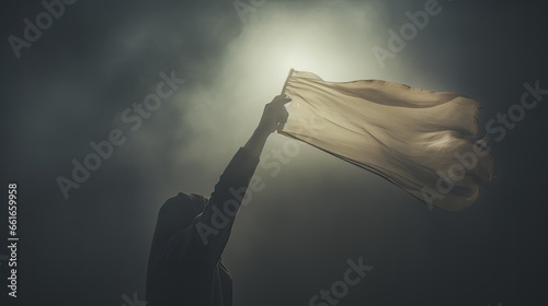Image of an outstretched hand clutching a white flag. photo