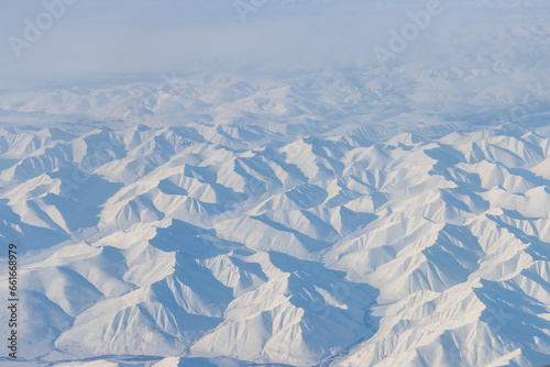Aerial view of snow-capped mountains. Winter snowy mountain landscape. Travel to the far north of Russia. Kolyma Mountains, Magadan Region, Siberia, Russian Far East. Great for the background.