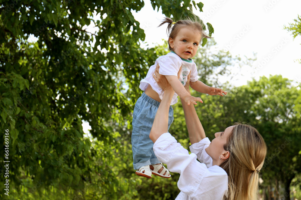 Mother with her daughter spending time together in park. Space for text Mother with her daughter spending time together in park. Space for text