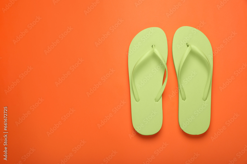 Stylish light green flip flops on orange background, top view. Space for text Stylish light green flip flops on orange background, top view. Space for text