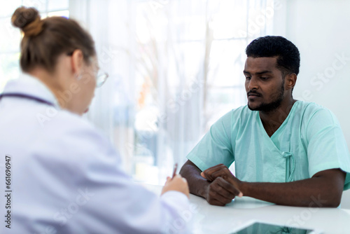 Physician examining male patient in hospital room. Man Patient talking to Doctor  at hospital. .