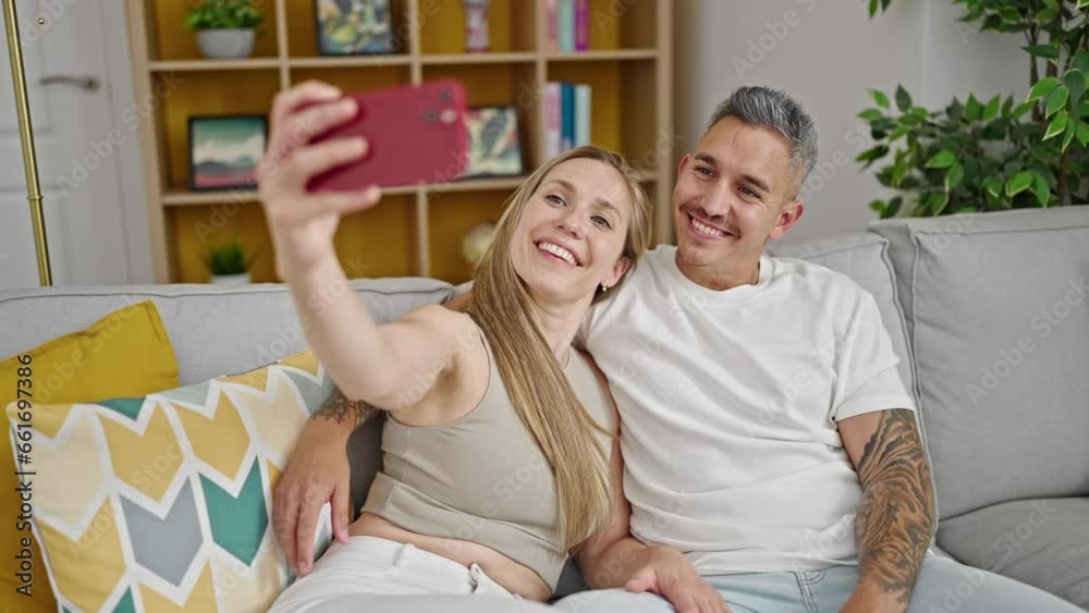 Man and woman couple make selfie by smartphone sitting on sofa at home Man and woman couple make selfie by smartphone sitting on sofa at home