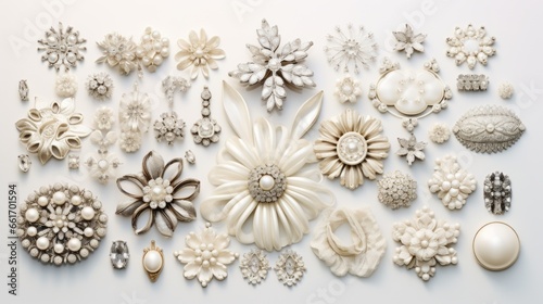 A collection of white and off-white brooches and pins arranged in a flat lay style on a white background, creating a vintage and elegant image. The brooches and pins are of various sizes, shapes and