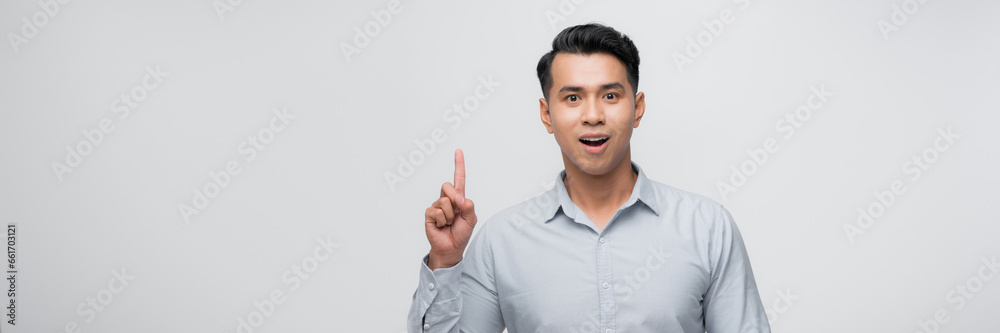 Young handsome man pointing finger up with successful idea. exited and happy. number one. Young handsome man pointing finger up with successful idea. exited and happy. number one.