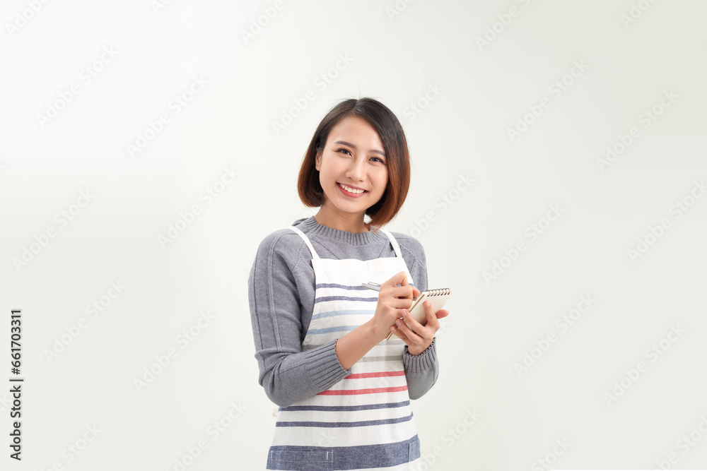 young friendly waitress in apron making notes in notepad, she smiling while taking order young friendly waitress in apron making notes in notepad, she smiling while taking order