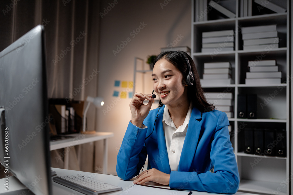 Asian woman wearing headphones and talking to customers. Call center employees answer the phone to help and answer questions from customers who call to use the service. Call center concept. Asian woman wearing headphones and talking to customers. Call center employees answer the phone to help and answer questions from customers who call to use the service. Call center concept.