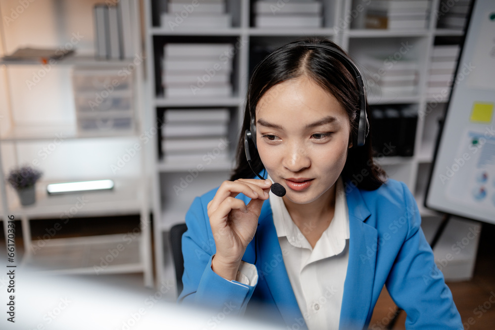 Asian woman wearing headphones and talking to customers. Call center employees answer the phone to help and answer questions from customers who call to use the service. Call center concept. Asian woman wearing headphones and talking to customers. Call center employees answer the phone to help and answer questions from customers who call to use the service. Call center concept.