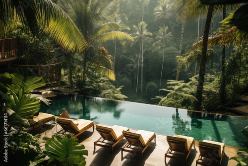 View of swimming pool and sunbeds in tropical jungle resort  Creating a serene and relaxing ambiance surrounded by the nature. Bali  Indonesia.