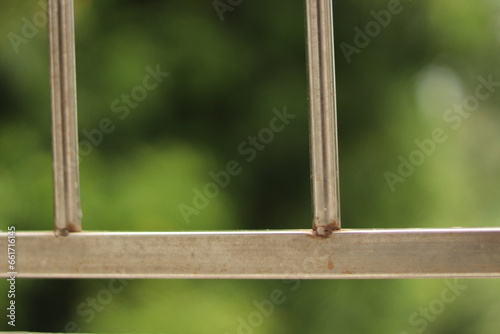 A Chrome silver coloured horizontal railing joints with bokeh background 