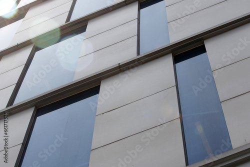 The building s glass reflects the blue sky