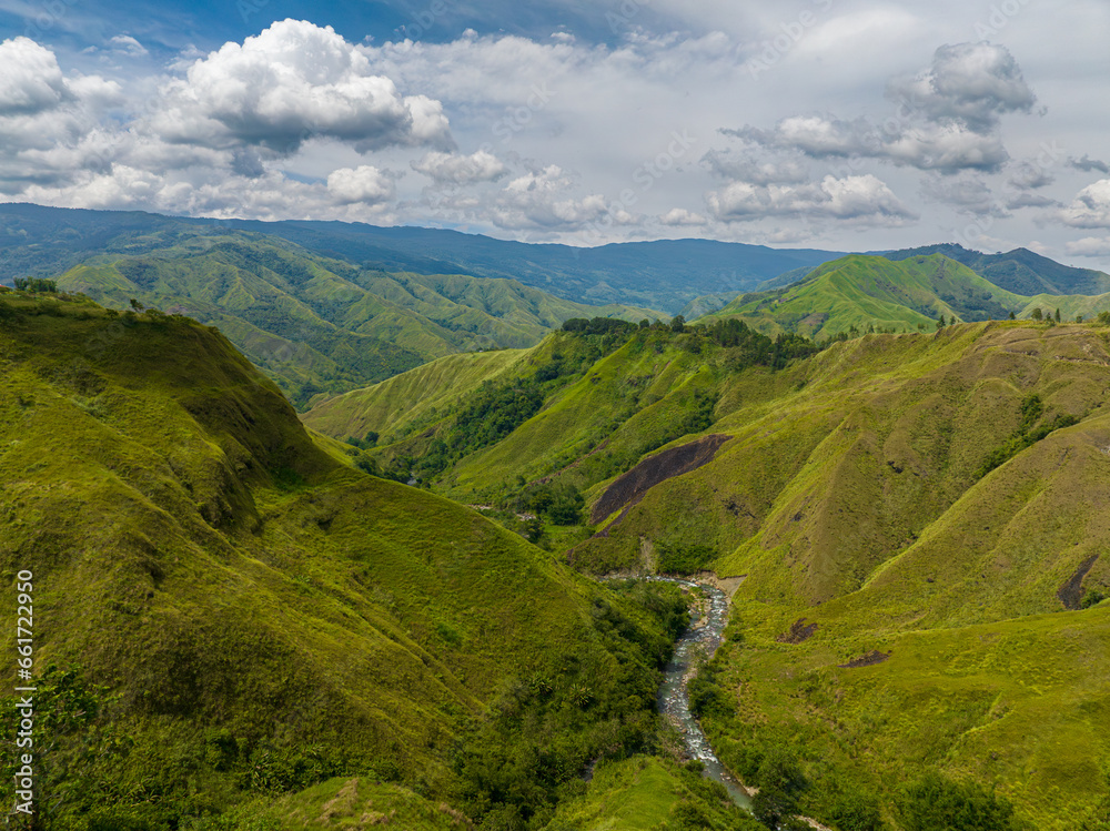 Aerial view of mountain valley and green hill. Tropical mountain with riverbanks. Mindanao, Philippines.