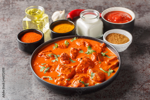Traditional Indian dish Chicken tikka masala with spicy curry meat in bowl over dark concrete background closeup. Horizontal © FomaA