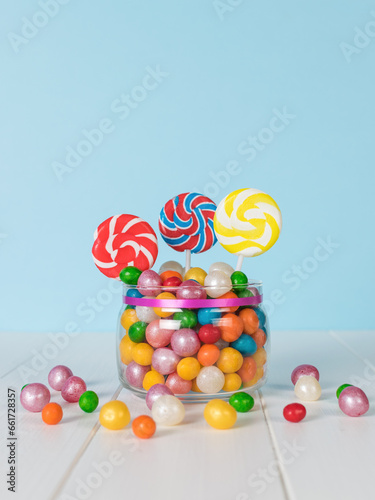 A jar with colorful candies for a party on a wooden table.