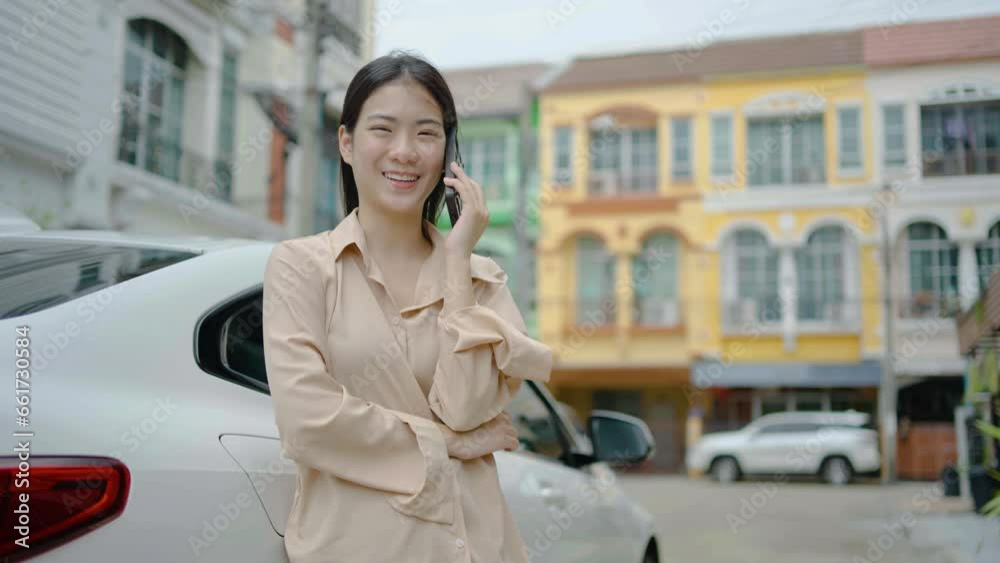 Beautiful girl tourist calling phone standing near car at summer weekend. Asian woman talking at smartphone in her village, Female enjoys talking phone Beautiful girl tourist calling phone standing near car at summer weekend. Asian woman talking at smartphone in her village, Female enjoys talking phone