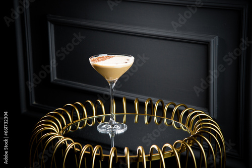 iced latte with foam in a martini glass on a dark background photo