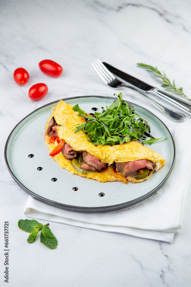 Breakfast of eggs with meat, herbs and drops of sauce in a round plate side view