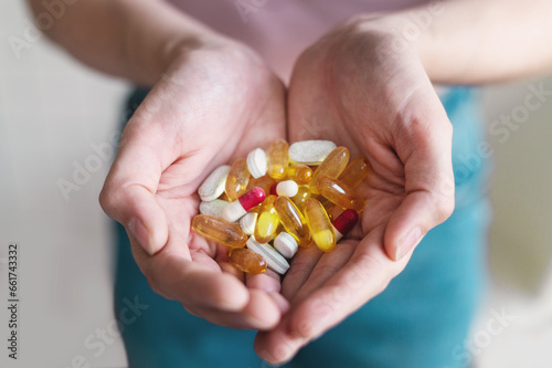 Close-up of female hands holding a handful of vitamin tablets. Omega 3 and other nutrients. Body care products that boost immunity