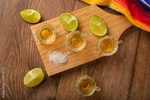 Tequila shots with salt and lime on a bar table. Shots of tequila and typical mexican elements. photo