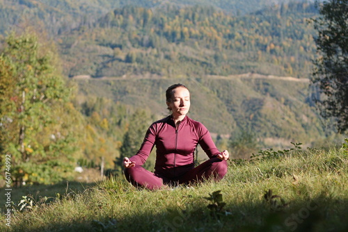 woman practices yoga outdoor in mountain landscape
