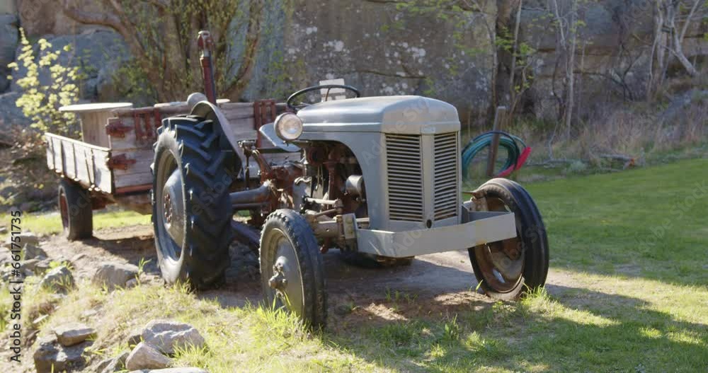 Slow-motion footage of an old cargo tractor parked on the grass on a sunny day