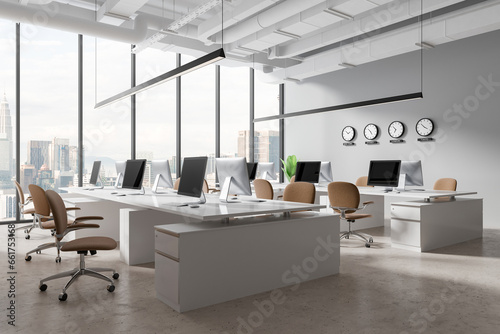 Modern office interior with pc monitors, world clock and panoramic window