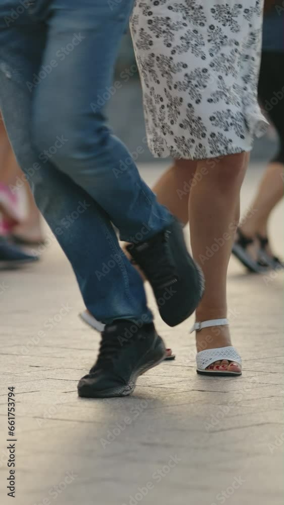 Vertical Screen: Closeup people's legs in summer clothing, dancing on an open terrace in the evening. People actively and joyfully spending their free time. Concept of active leisure Vertical Screen: Closeup people's legs in summer clothing, dancing on an open terrace in the evening. People actively and joyfully spending their free time. Concept of active leisure