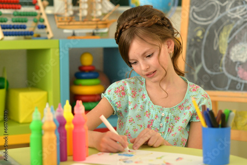Portrait of cute girl drawing picture at home