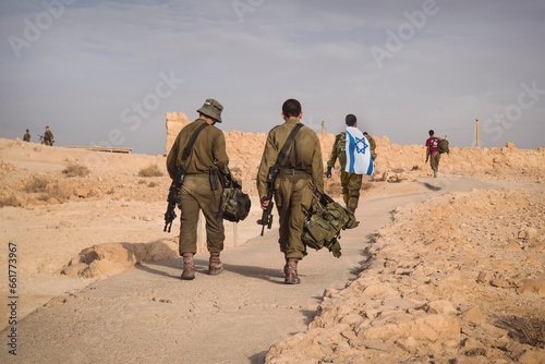 Valokuva Back shot of several soldiers of israel army walking with israel national flag