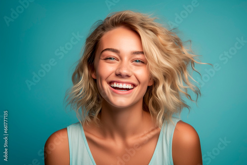 Mujer rubia con sonrisa en la cara, expresa alegria y felicidad