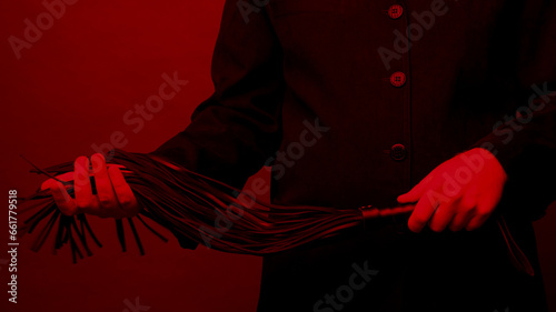 Male dominant holds a leather whip Flogger for hard BDSM sex with spanking