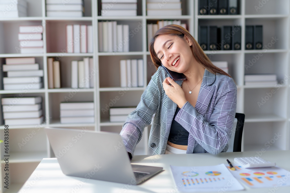 Successful asian businesswoman making a professional phone call in her office. Successful asian businesswoman making a professional phone call in her office.