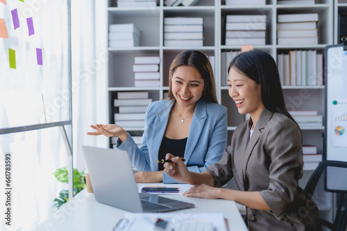 Two Asian businesswoman teamwork discussing and using laptop. Two Asian business women are talking and consulting.